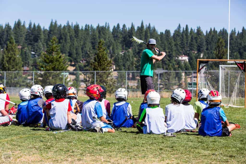 lacrosse team coach demonstrating proper form