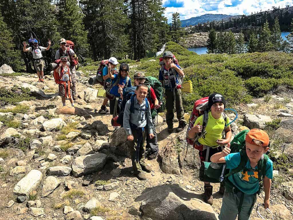 boys backpacking crew hiking along a trail