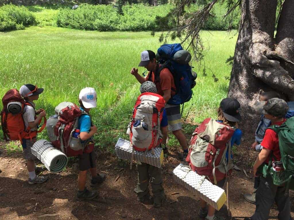 boys backpacking crew stopped on a trail