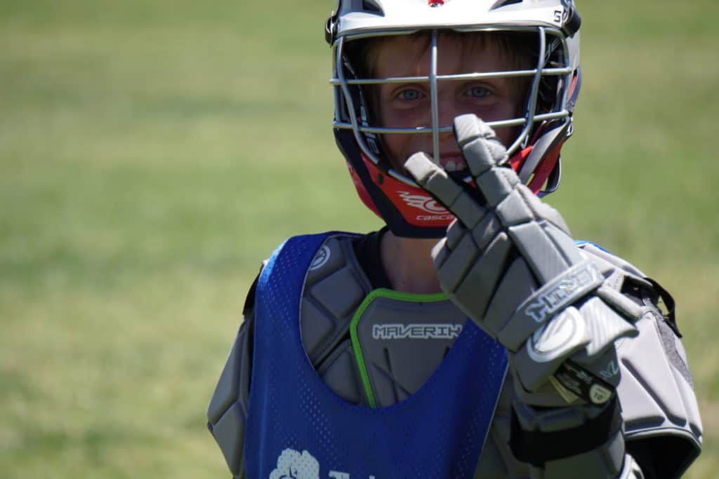 boys lacrosse camp team member giving the peace sign