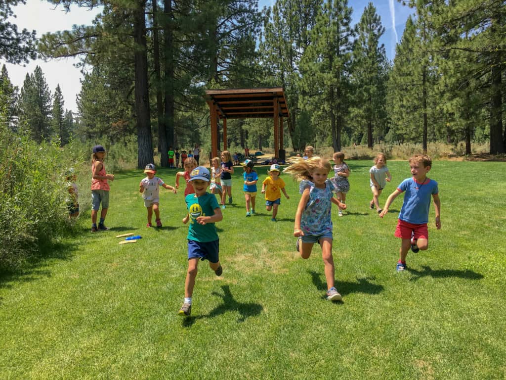 elementary students running through a field