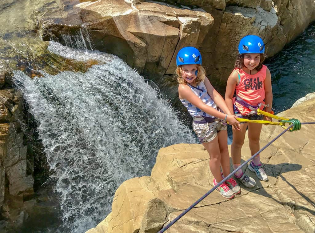 girl rock climbers using a rope to keep steady