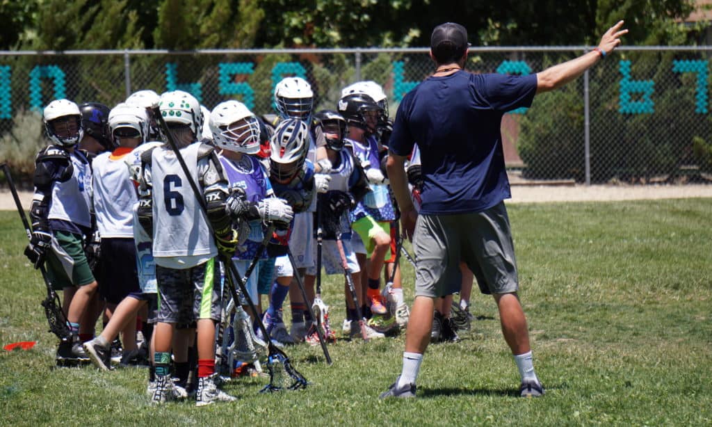 coach directing the lacrosse camp team