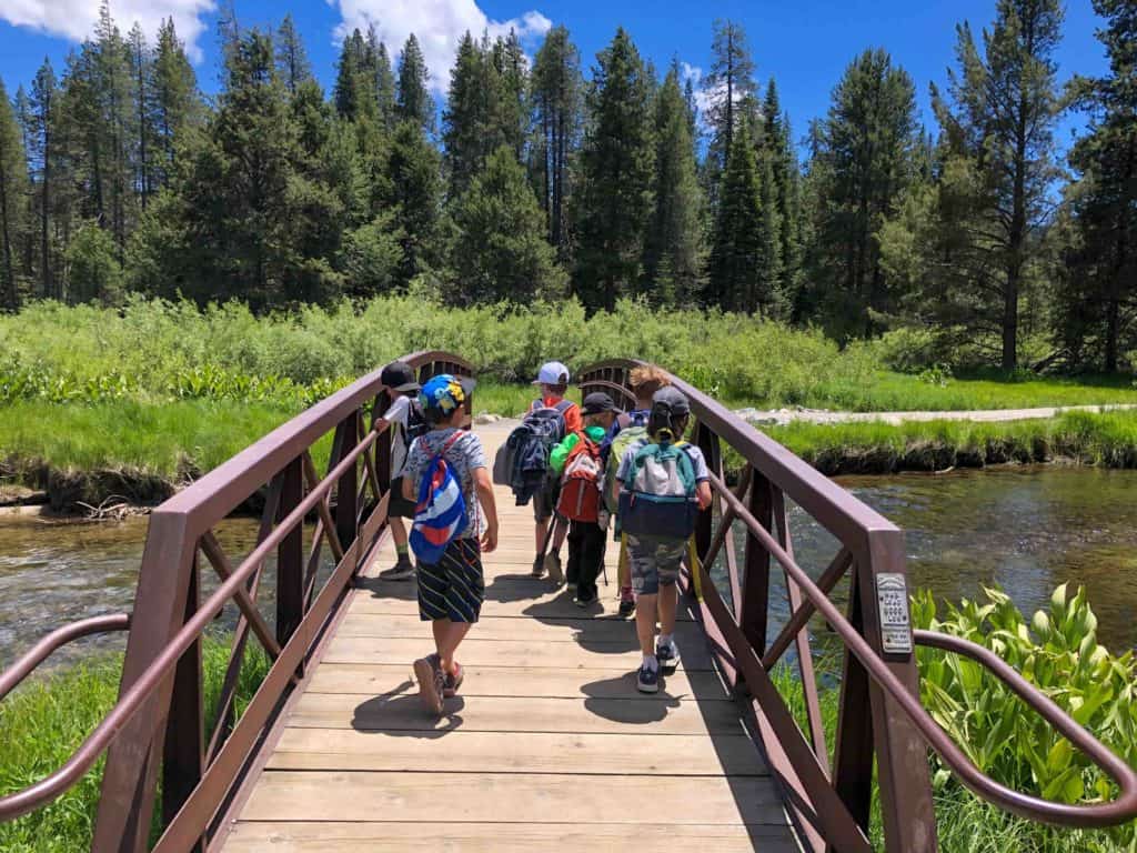 art campers walking on a bridge