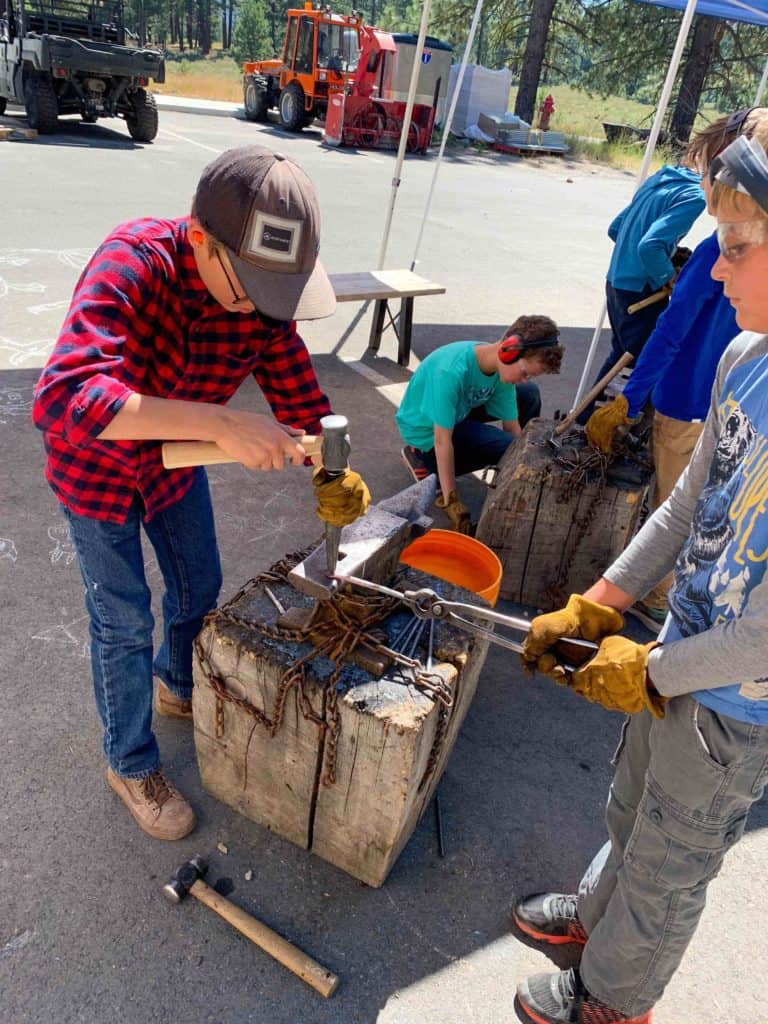 two students using an anvil