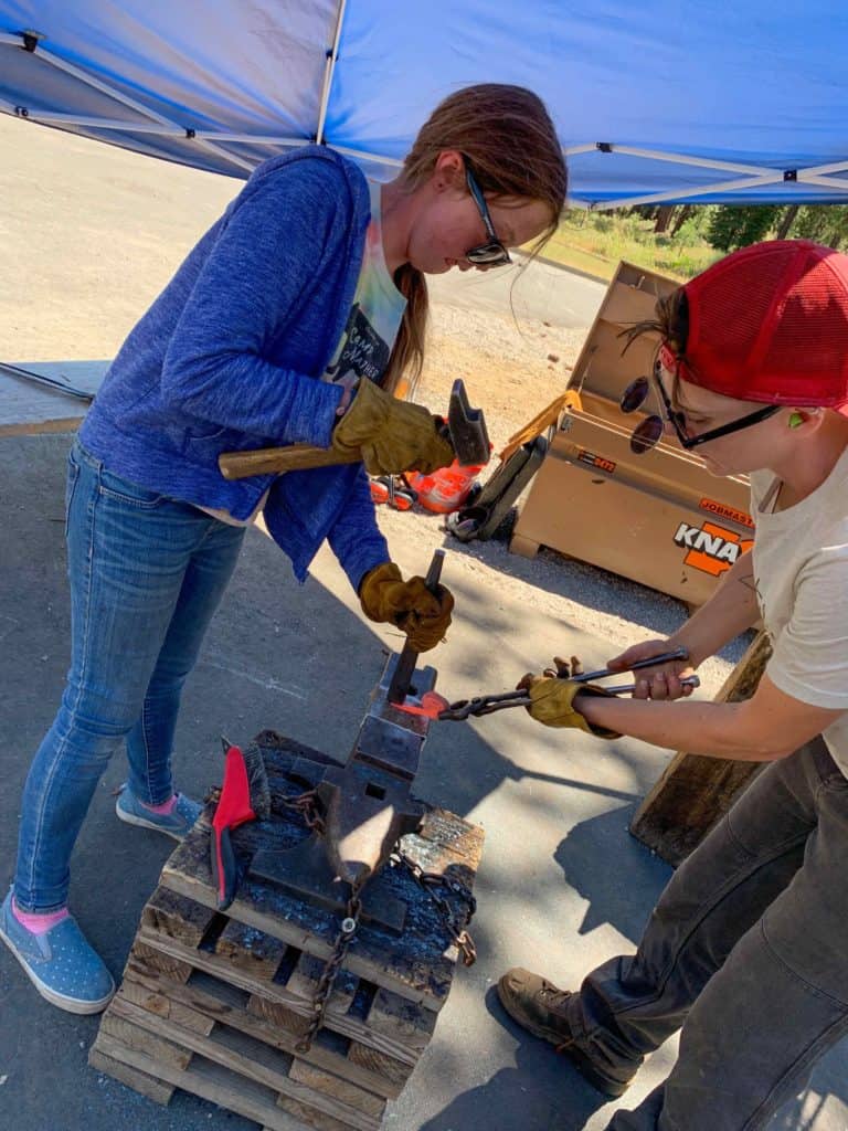two students using an anvil