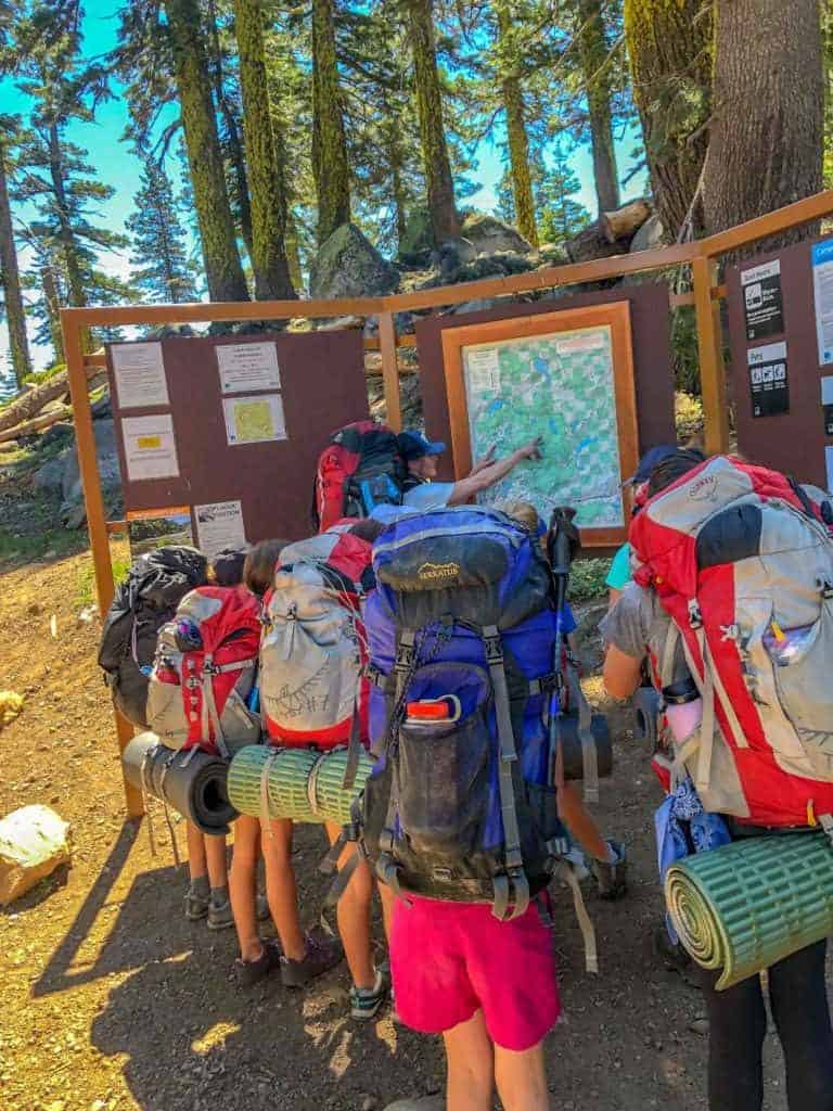 girls backpacking crew viewing a trail map