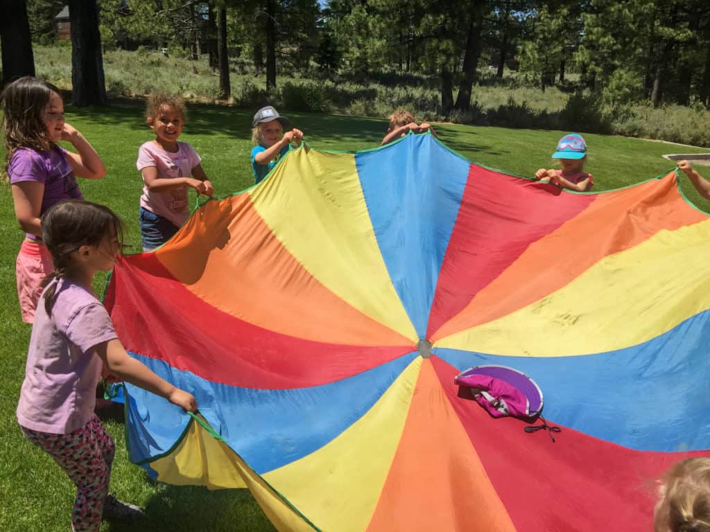 kids holding a circular parachute