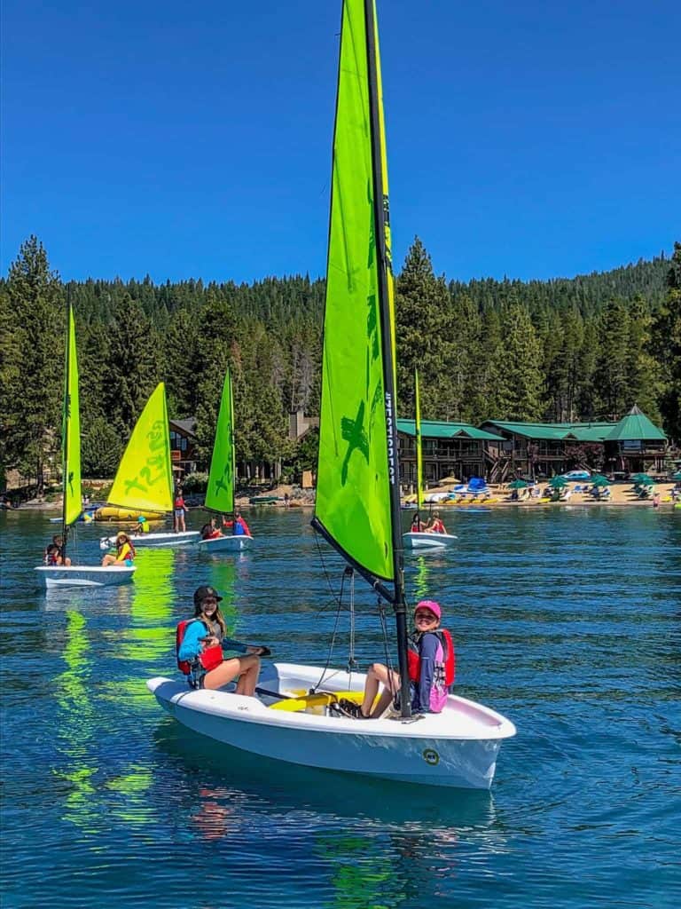 students in a sailboat on the lake