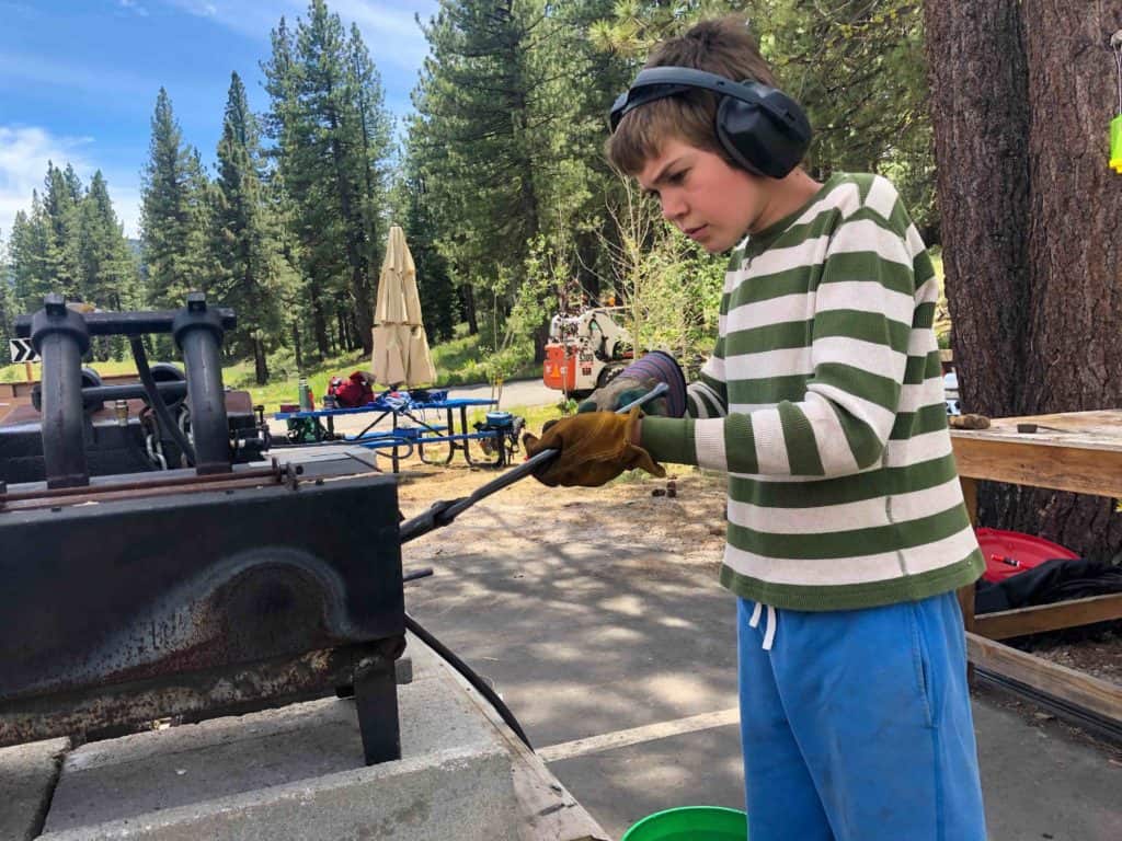 student working a forge