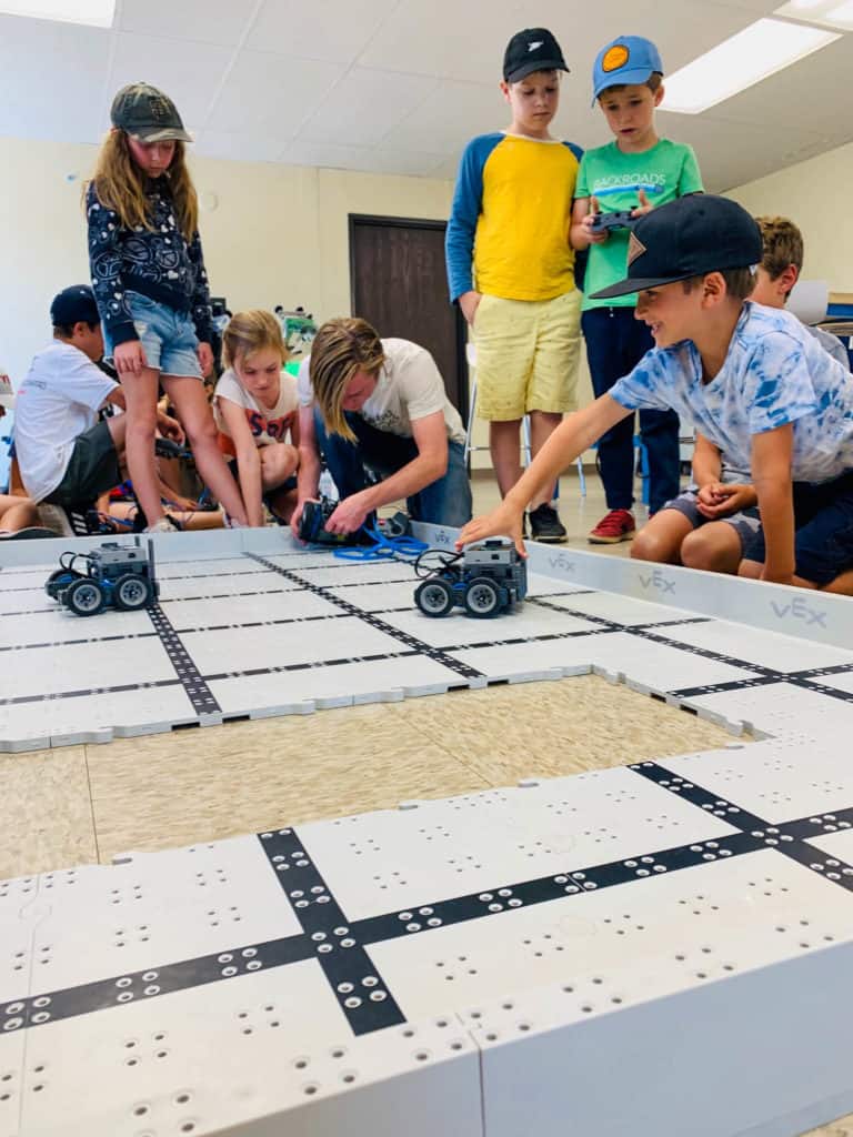 kids driving their robo cars on a table