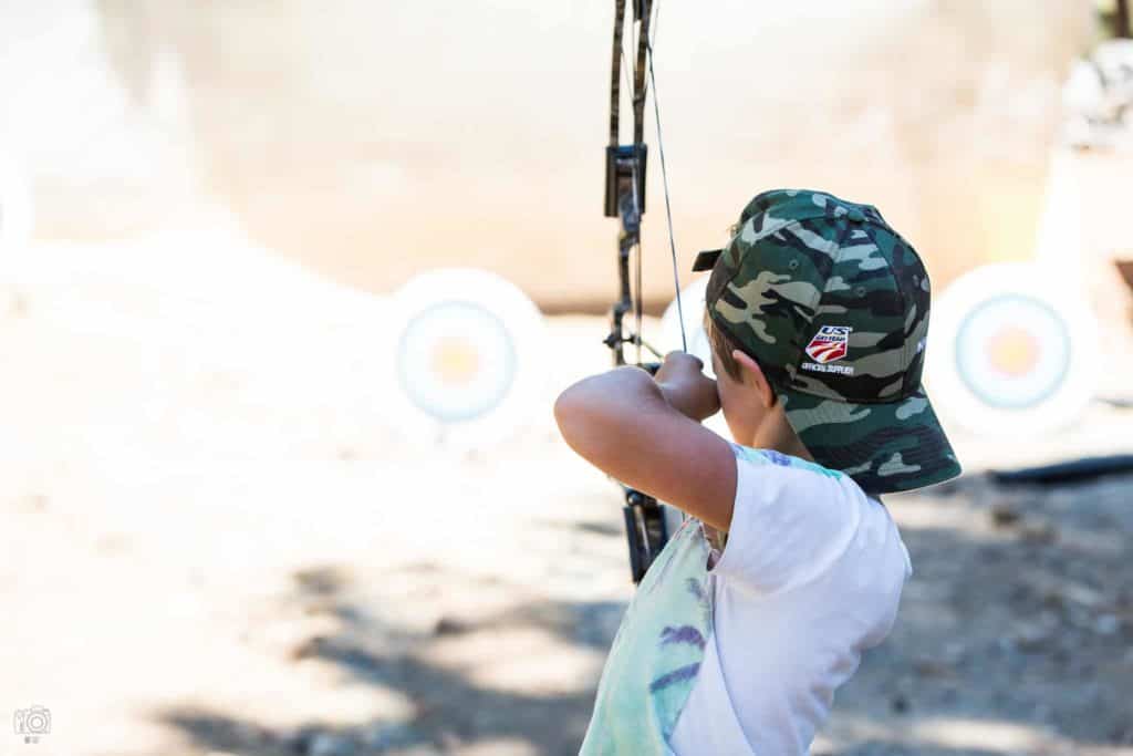 a boy draws his bow and takes aim