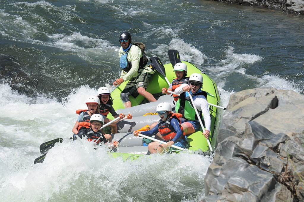 students and teacher rafting down rapids